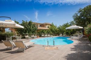 una piscina con sillas y sombrilla en Hotel Cannamele Resort, en Parghelia