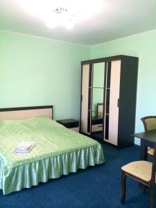 a bedroom with a bed and a table and a chair at Hotel Prestige in Astrakhan