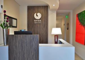 una oficina con recepción con un letrero de uws en la pared en Uvas Apart Hotel en Mendoza