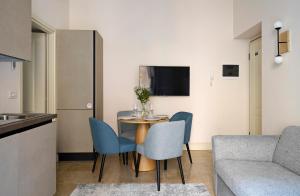 a living room with a table and chairs and a couch at numa I Loreto Apartments in Milan