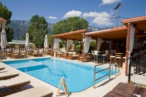 a pool at a hotel with tables and chairs at Porto Marina in Chrysi Ammoudia
