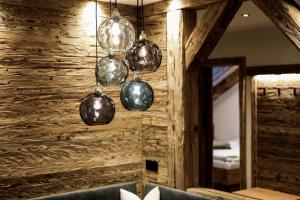 a chandelier hanging from a wooden wall in a room at Ferienhof Alte Post, Apartments in Weissbriach