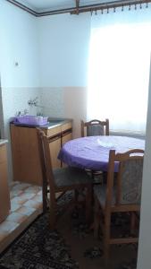 a kitchen with a purple table and chairs and a sink at Apartman Tamara in Žabljak