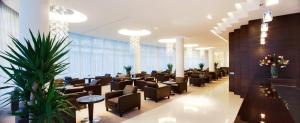 a waiting room with chairs and tables and plants at Hotel Aristos in Zagreb