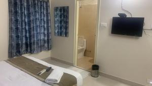 um quarto com uma cama, uma televisão e um WC em Homewood Suites ( Service Apartments) em Hyderabad