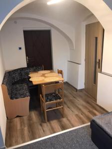 a room with a table and a kitchen with a door at Apartmán u Junků in Pernink