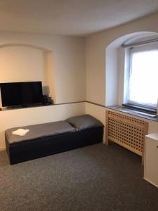 a small room with a bed and a window at Apartmán u Junků in Pernink