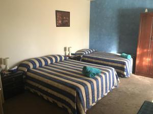 two beds with striped sheets in a room at Muswellbrook Northside Bed & Breakfast in Muswellbrook