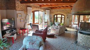 un soggiorno con sedie, TV e camino di Luxury family villa in the heart of Gascony. Large pool & gorgeous view a Tourdun