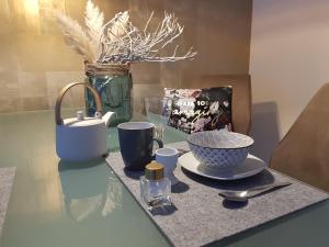 una mesa de cristal con un tazón y tazas. en Ferienwohnung Königsquellenpark, en Bad Wildungen