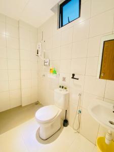 Baño blanco con aseo y lavamanos en The Sweet Escape @ Imperio Professional Suite en Alor Setar