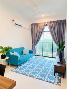 a living room with a blue couch and a large window at The Sweet Escape @ Imperio Professional Suite in Alor Setar