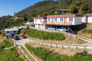 a house on top of a hill with cars parked at Cabañas Centenilla in Niebla
