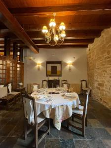 a dining room with a table and a chandelier at Posada Torre Palacio La Taxuela in Villanueva la Lastra