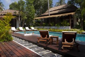 a pool with lounge chairs and a table next to a resort at Amaya Boutique Resort in Srithanu