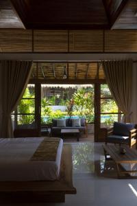 a bedroom with a bed and a living room at Amaya Boutique Resort in Srithanu