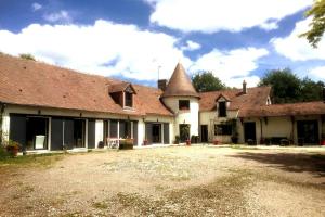 an old house with a large yard in front of it at Le mur des beaunes in Pruniers