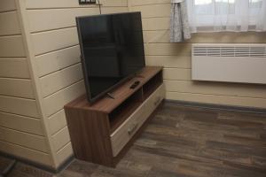 a flat screen tv on a wooden stand in a room at Гостевой дом ЧаеЧка in Sortavala