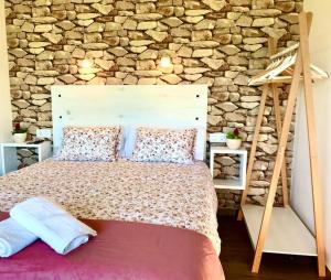 Un dormitorio con una pared de piedra y una cama grande. en Casa Nueva de Vigo con Jacuzzi y chimenea, en Mos