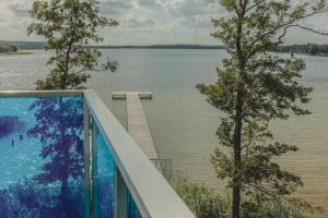 a balcony with a view of the water and a dock at Apartament 309 in Boszkowo
