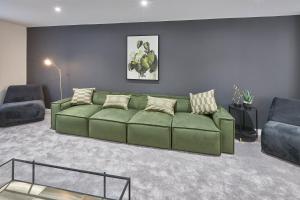 a living room with a green couch and two chairs at Host & Stay - Littlebeck House in Sleights