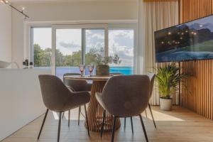 a dining room with a table and chairs and a large window at Apartament 309 in Boszkowo