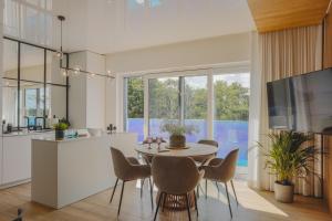a kitchen and dining room with a table and chairs at Apartament 309 in Boszkowo