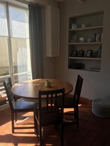 a table and chairs in a room with a window at Le Caribou d'Eva in Portbail