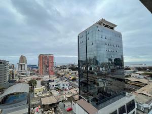 un edificio alto de cristal en la cima de una ciudad en Amplio Departamento - Edificio Tranquilo, en Antofagasta
