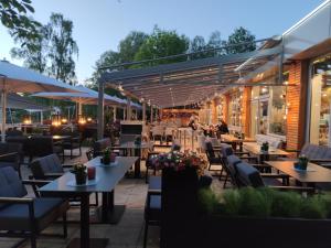 a restaurant with tables and chairs in front of a building at Hotel am Springhorstsee in Großburgwedel