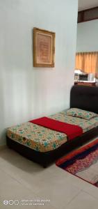 ein kleines Bett in einem Zimmer mit in der Unterkunft Homestay Zulaika Kota Aur in Kepala Batas