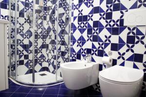 a blue and white bathroom with a toilet and a sink at Appartamento Redentore in Venice