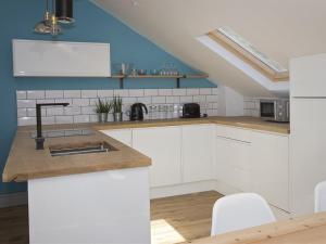 a kitchen with white cabinets and a sink at The Loft Winchester in Winchester