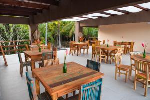 マラウにあるPousada Sitio da Biaの木製のテーブルと椅子、パティオ付きのレストラン