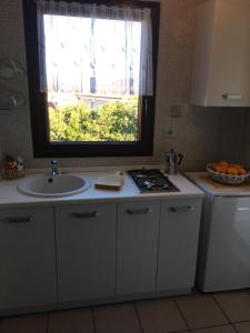 une cuisine avec un évier et une fenêtre dans l'établissement Apartmani Mirjana Umag, à Umag