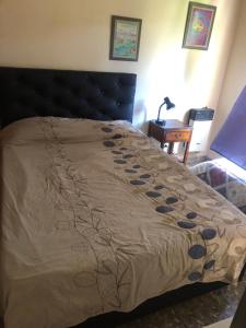 łóżko z czarnym zagłówkiem w sypialni w obiekcie Alquiler de Casa en La Falda w mieście La Falda