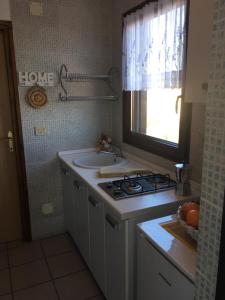 a kitchen with a stove and a sink and a window at Apartmani Mirjana Umag in Umag