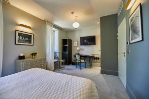 a bedroom with a bed and a dining room at Olivier Leflaive Hôtel Restaurants in Puligny-Montrachet