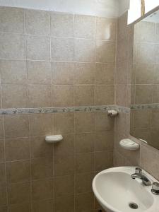 Un baño alicatado con lavabo e inodoro. en Hosteria EL PARRAL, en Mina Clavero 17 fotos más