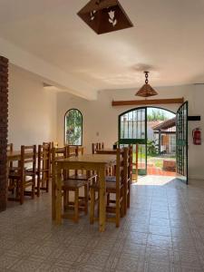 a dining room with a table and wooden chairs at Hosteria EL PARRAL in Mina Clavero