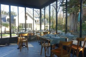 a dining room with tables and chairs and windows at Chambre d'hôtes Les Îles Vagabondes in Saint Malo