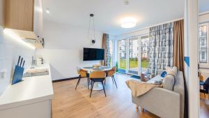 a kitchen and living room with a couch and a table at Nexo, Sun & Snow in Puck