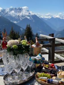 a table with wine glasses and food on top of a mountain at Artsy Luxurious Ski-In-Out-Chalet in Bagnes