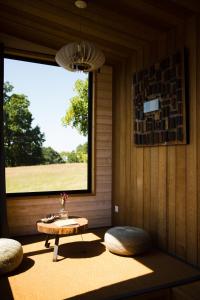 a room with a table and two chairs and a window at La Tiny du Parc : Saint Symphorien des Monts in Saint-Symphorien-des-Monts