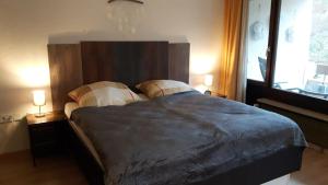 a bedroom with a large bed with two lamps at Appartementhaus im Grün in Bad Bellingen
