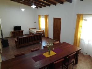 Una sala de estar con una mesa de madera y un sofá. en cabaña alojamiento Canto de las Aves, en San Rafael