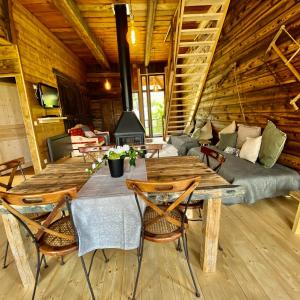 una mesa de madera y sillas en una habitación con sofá en Authentique grange savoyarde, en Albiez-Montrond