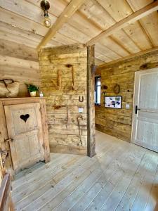 Habitación con paredes de madera y suelo de madera. en Authentique grange savoyarde, en Albiez-Montrond