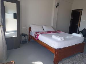 sypialnia z łóżkiem z dwoma ręcznikami w obiekcie HILLSCAPE w mieście Czerapuńdżi