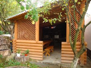 una casa de perros de madera con un banco en ella en Vyshenka Guest House, en Yaremche